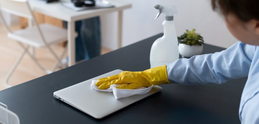 Mujer limpiando portátil con sumo cuidado