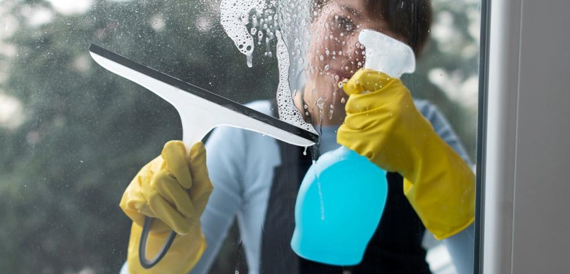Persona limpiando vidrios con elementos especializados