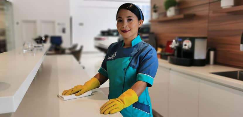 Profesional en Aseo de Misión Servir realizando limpieza responsable y eficiente en un espacio empresarial