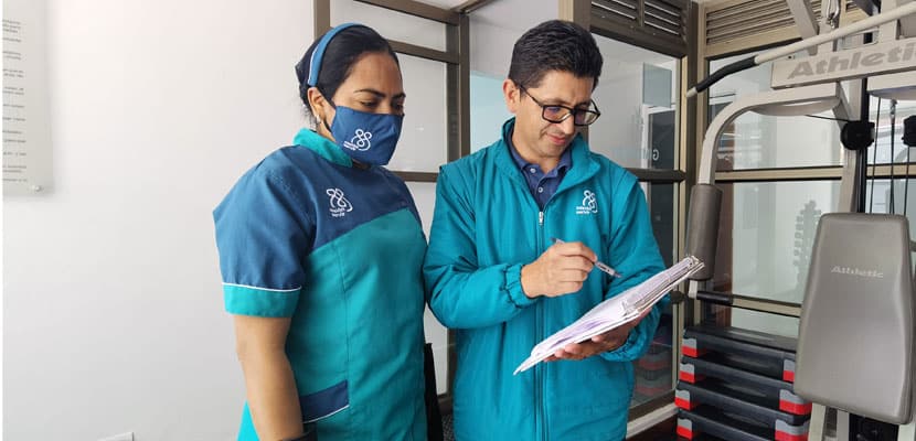 Dos profesionales de Misión Servir estudiando el código de colores mostrando cómo se clasifican los residuos hospitalarios