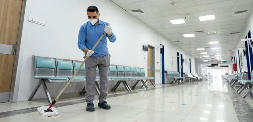 Hombre en pasillo de hospital con trapero demostrando las técnicas de mantenimiento más utilizadas y recomendadas por Misión Servir